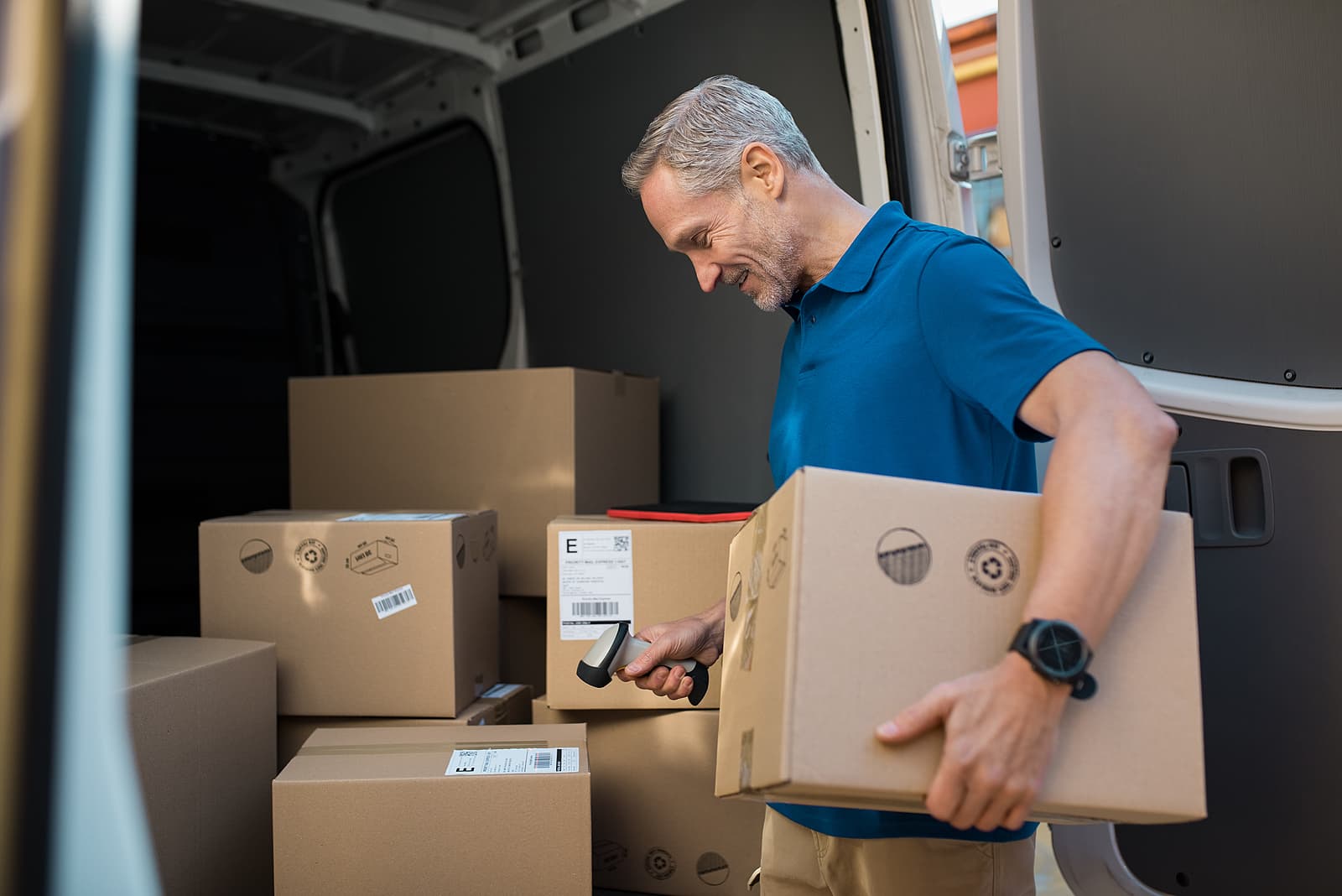 custom cardboard boxes - Delivery man scanning cardboard boxes