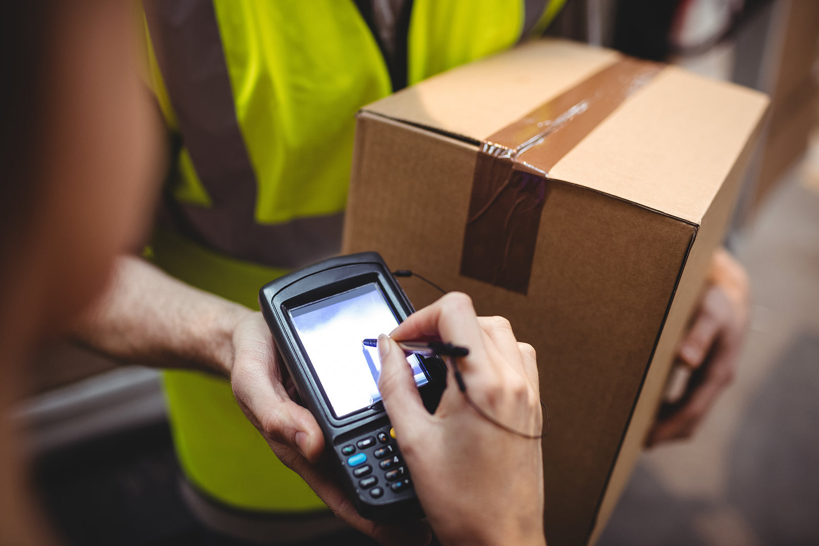 custom cardboard boxes - Woman signing on device to delivery parcel