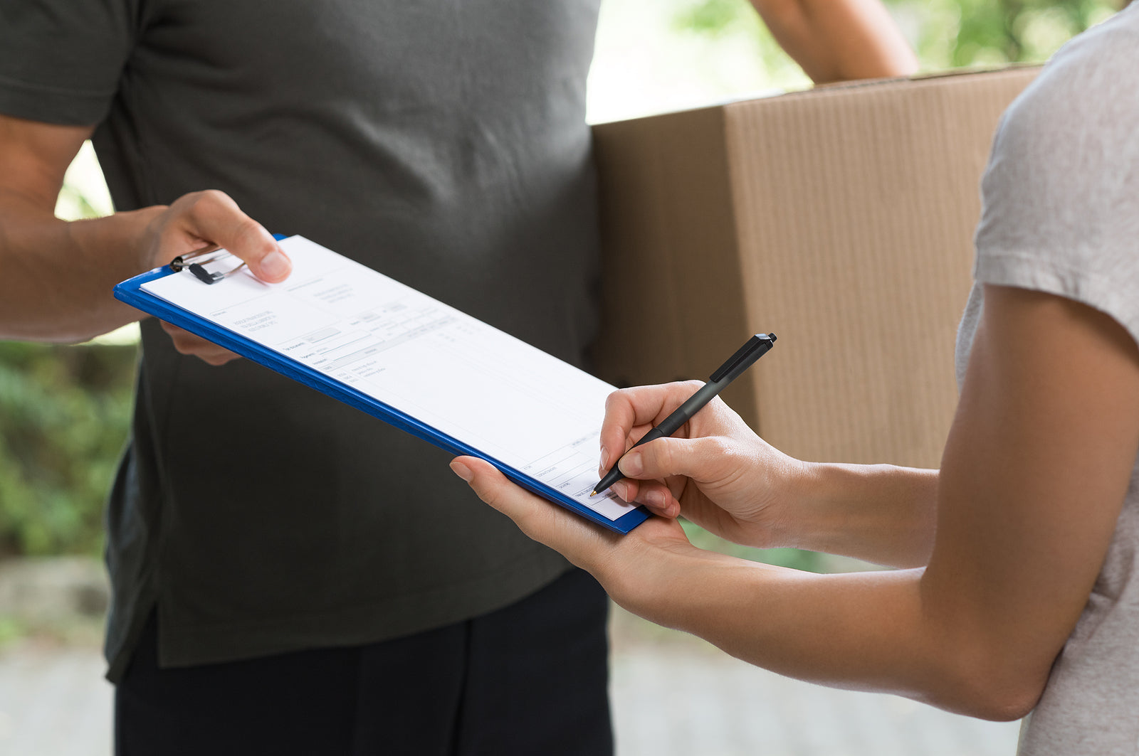 custom cardboard boxes - Woman signing receipt of delivery package