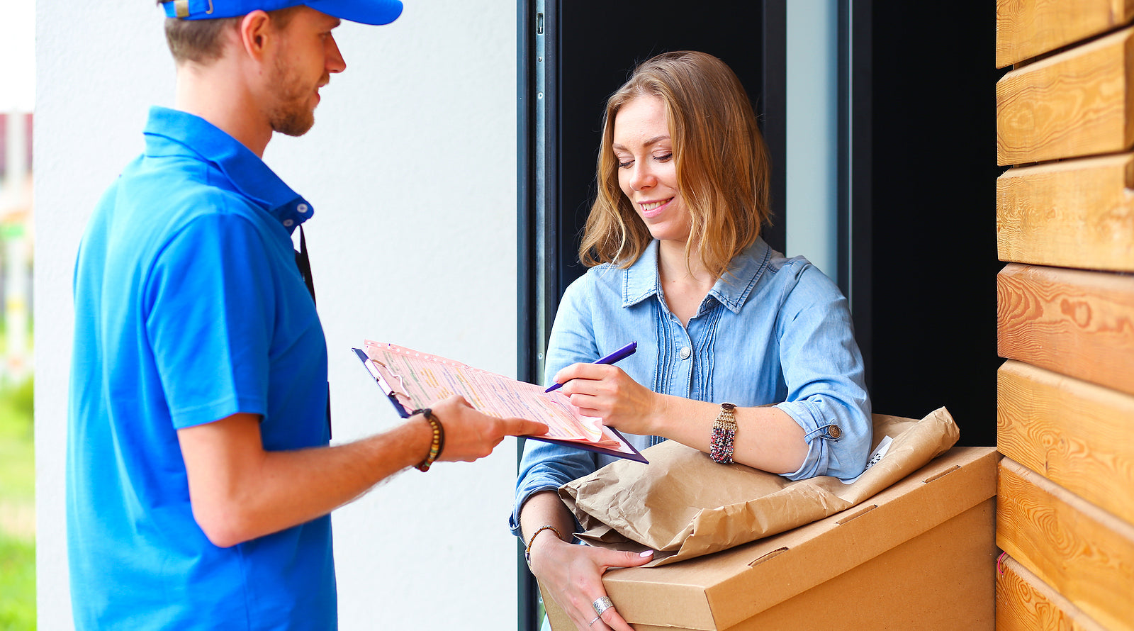 custom cardboard boxes - delivery man in blue uniform delivering parcel box