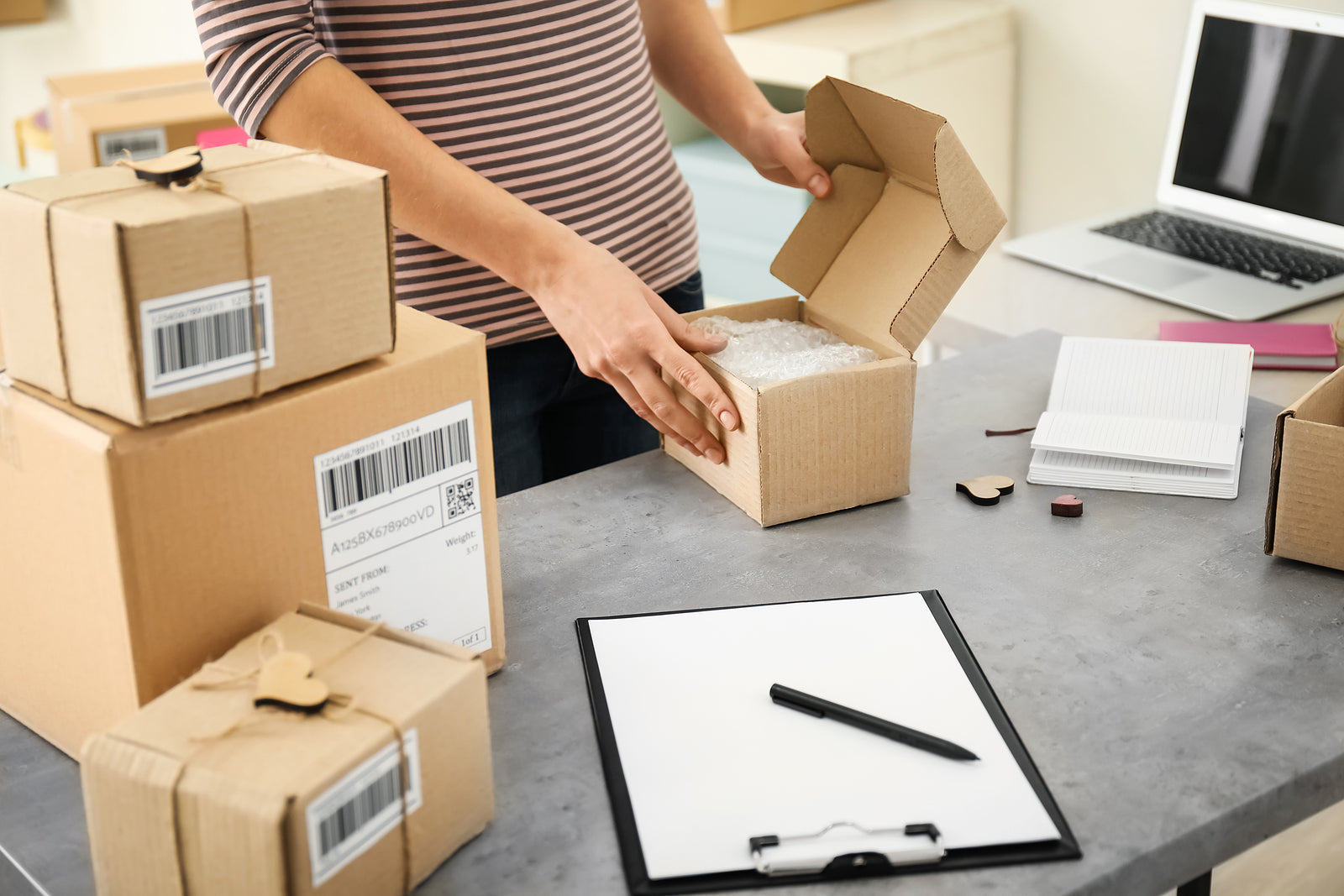custom cardboard boxes - woman preparing parcels for shipment